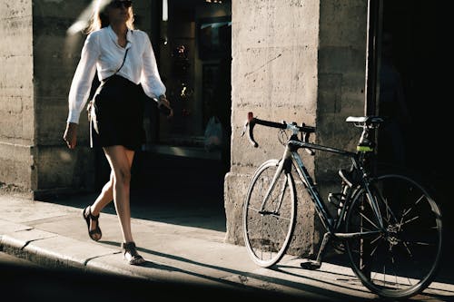 Wanita stylish berjalan di jalanan kota