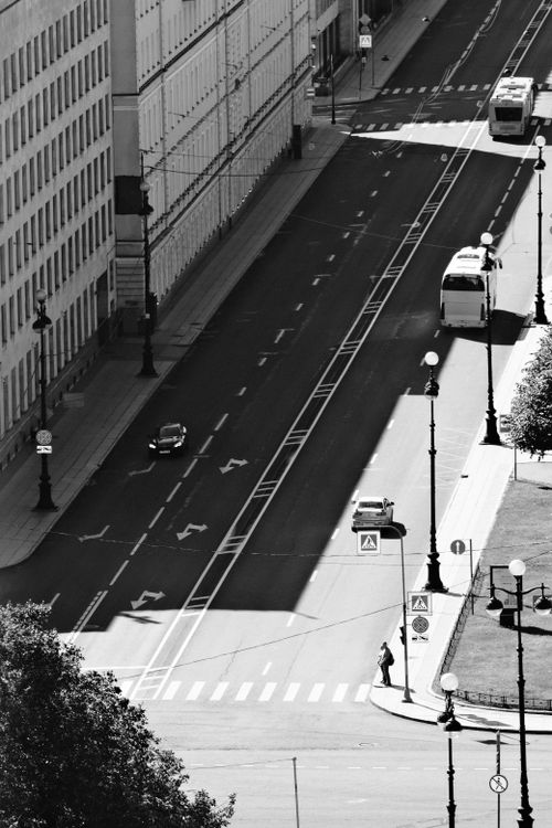 Free Aerial view of a quiet city street with public transport and pedestrian in black and white. Stock Photo
