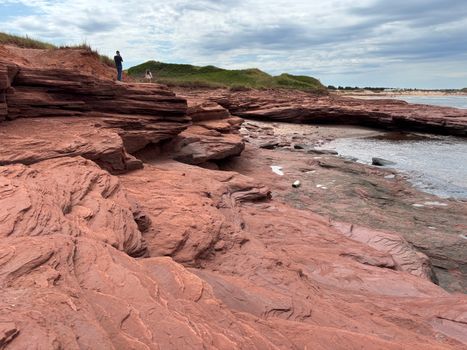 Explore the stunning red sandstone cliffs along the shore in Cavendish, PEI, Canada.