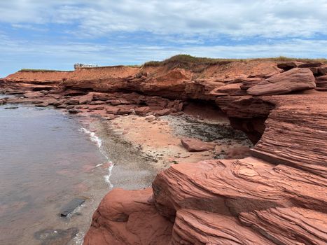 Explore the striking red sandstone cliffs along the shoreline of Cavendish, Prince Edward Island.