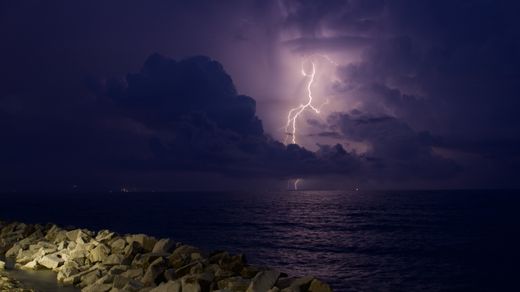 A lightning bolt over a rocky coastline — photo by Jan Dvorak on Pexels