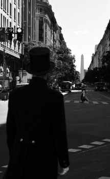 Black and white street view in Buenos Aires with the Obelisk visible, featuring a person in formal attire.