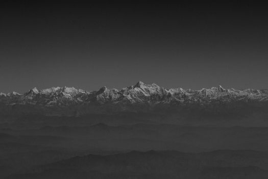 Black and white image of the snow-capped Xigaze mountains in Tibet. Aerial perspective showcasing winter landscape.