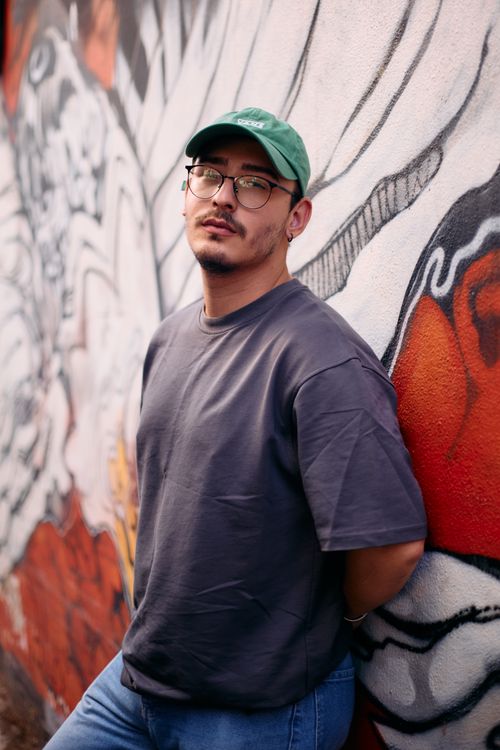 Free Casual portrait of a young man leaning against a colorful street art mural in Istanbul. Stock Photo