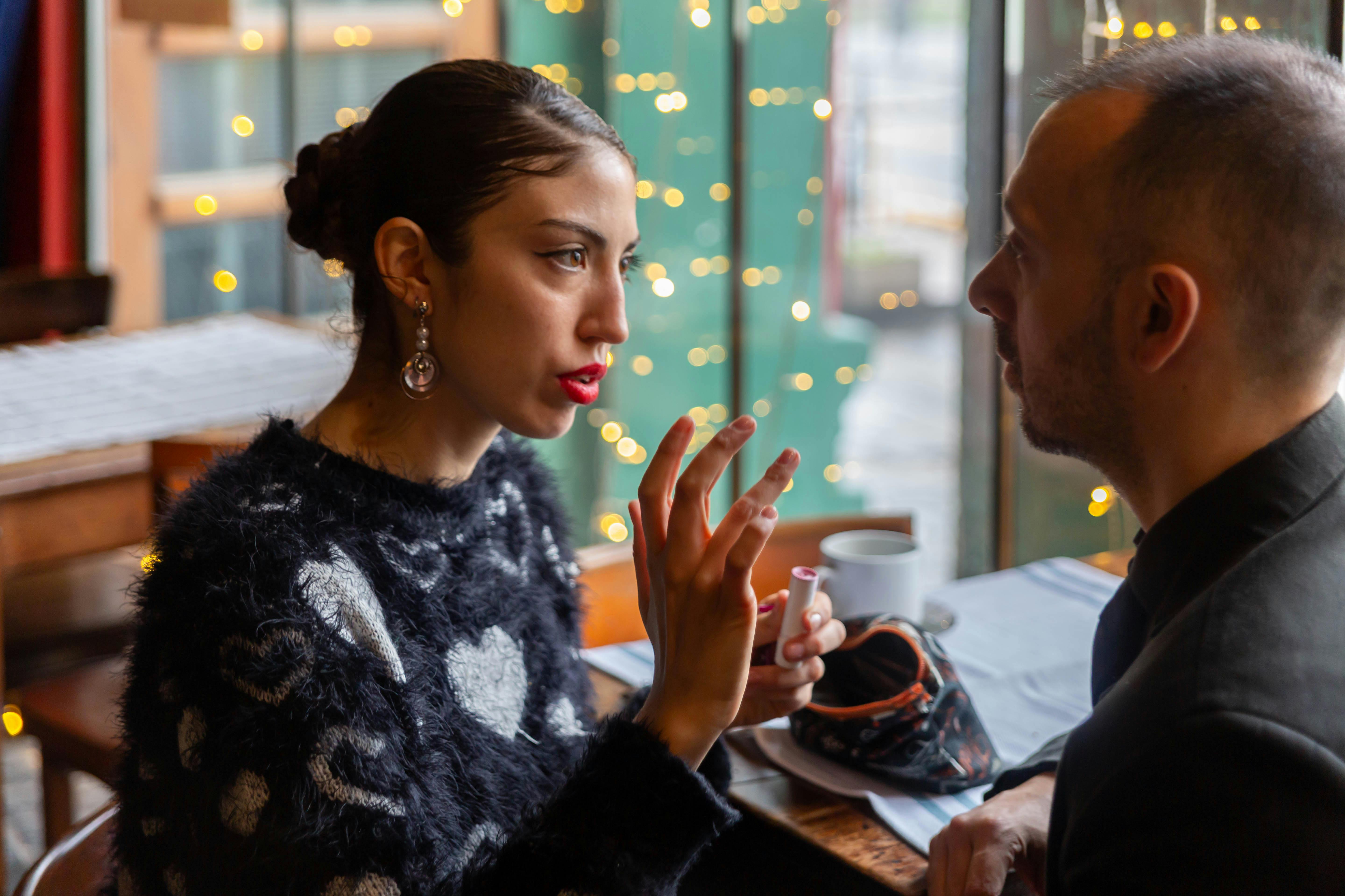 Coppia elegante seduta al tavolo del caffè mentre parla