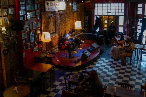 Free Cozy cafe in Mar del Plata with live guitar music performance, rich ambiance. Stock Photo