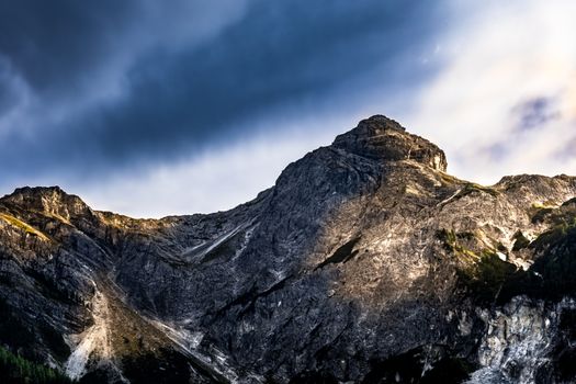 A rugged mountain peak captured under dramatic skies, showcasing nature's grandeur.