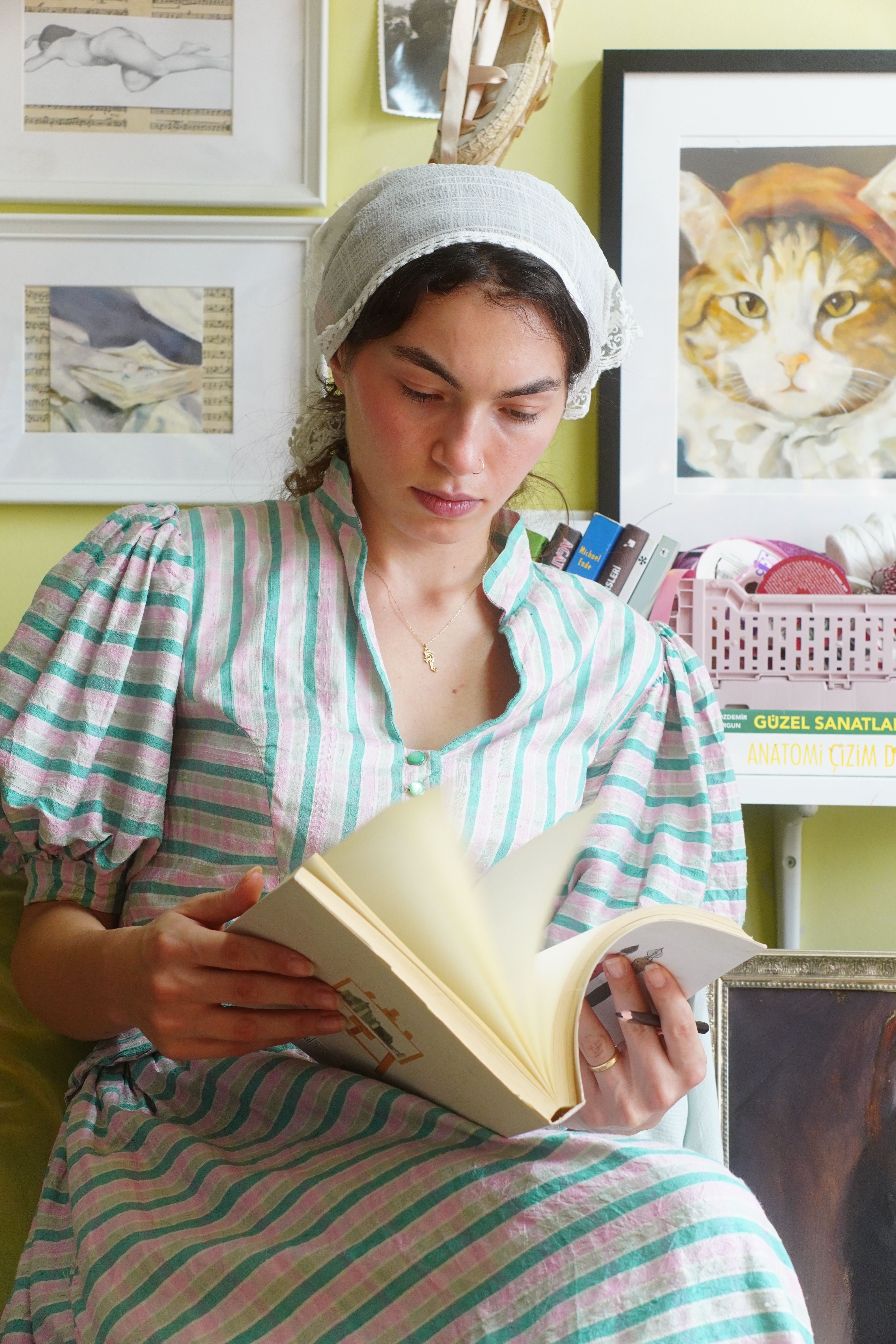 Woman enjoying a book in a cozy home with artful decor, relaxed atmosphere