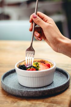 Indulge in a delightful creme brulee dessert topped with fresh berries, captured in vibrant detail.