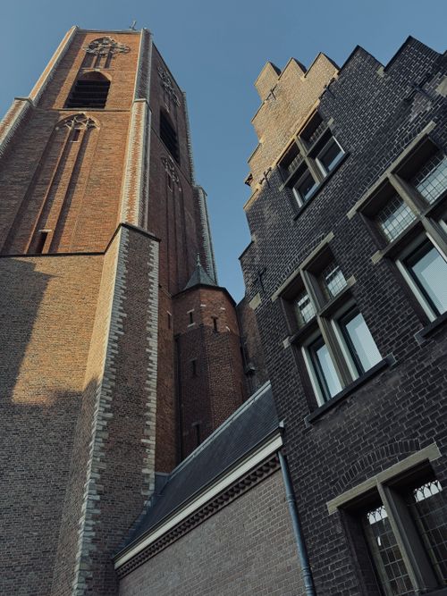 Free A striking view of historic brick buildings in Amsterdam showcasing Gothic architectural styles. Stock Photo