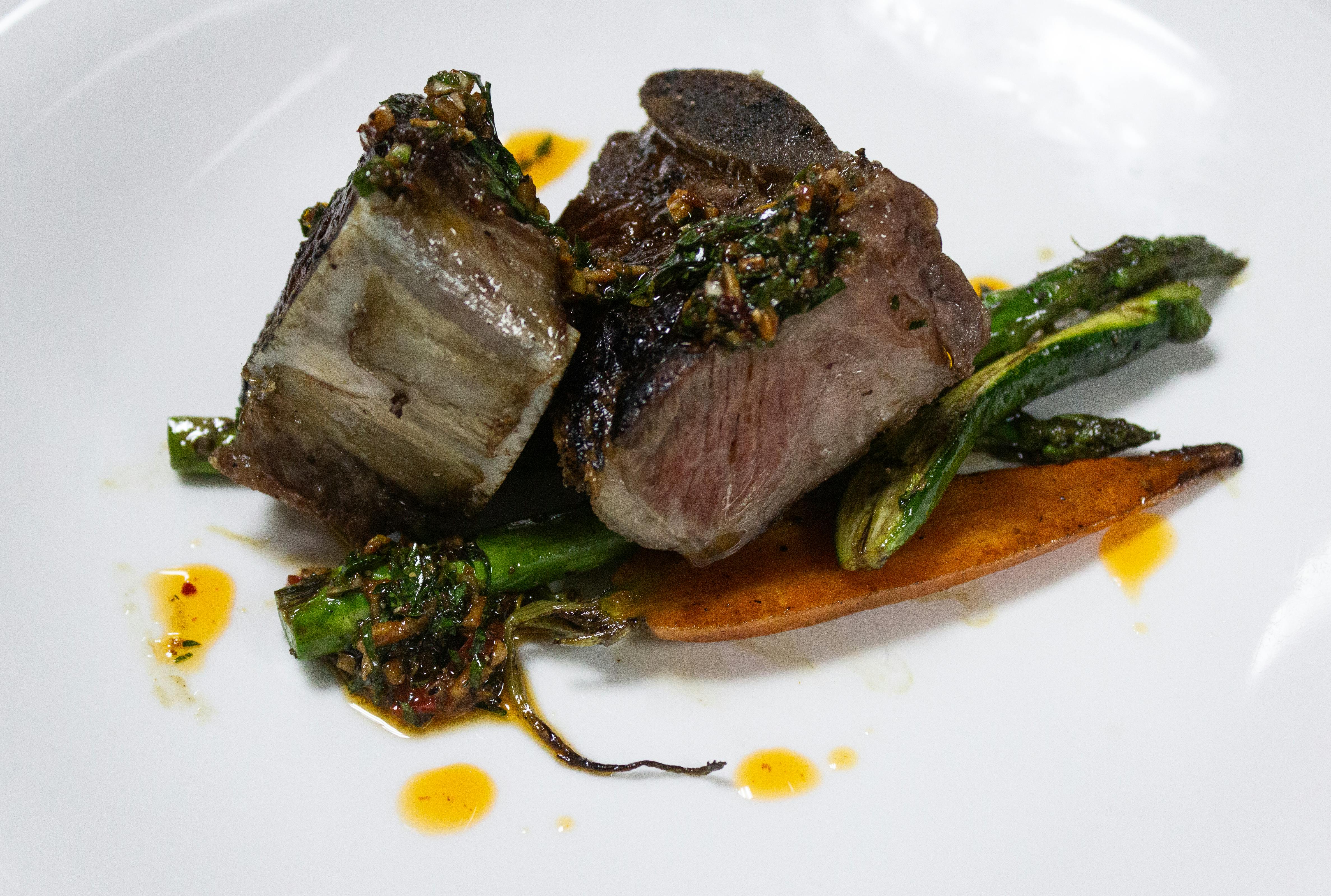 Prato gourmet de filé com aspargos, destacando a alta gastronomia em hotéis de luxo.