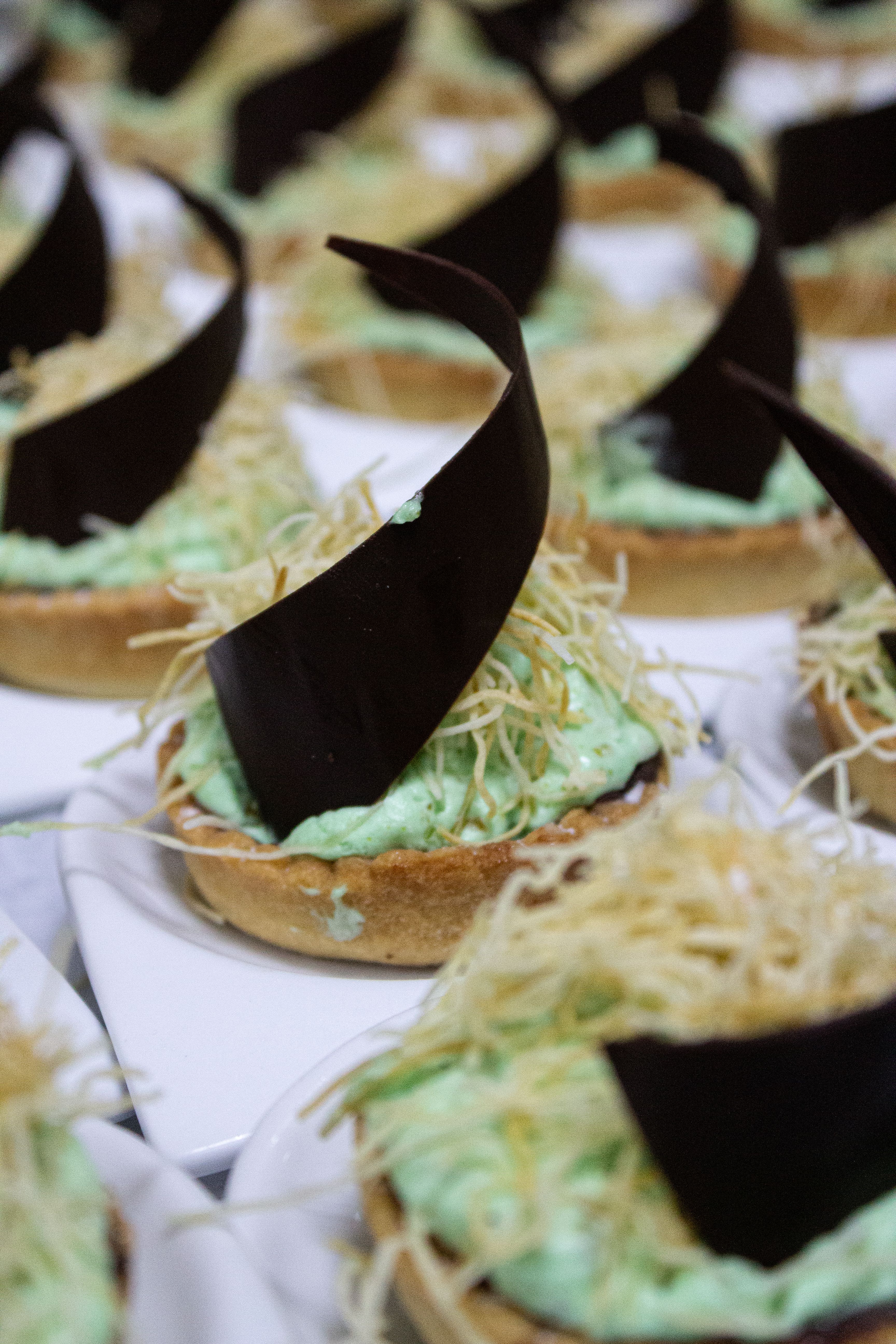 Gourmet dessert tarts with chocolate and mint cream on elegant plates.