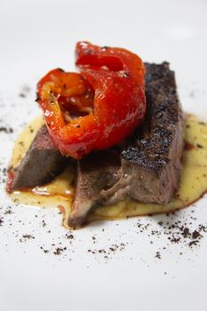 Delicious gourmet steak topped with roasted peppers, perfect for fine dining photography.