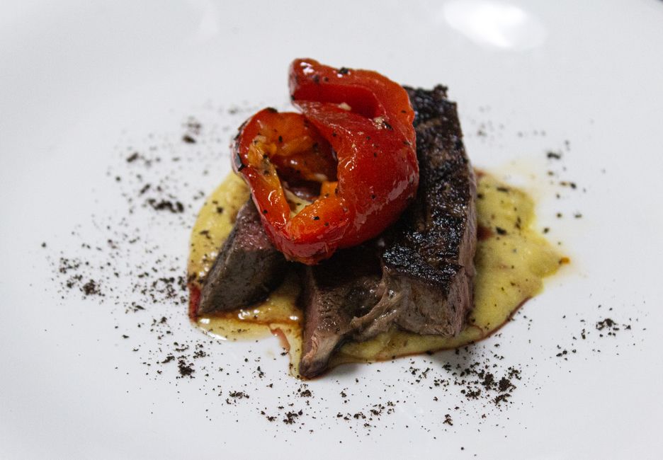 Gastronomia de luxo: Sumptuous gourmet steak dish with roasted red peppers.