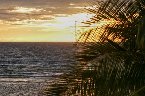 Free A tranquil view of a sailboat on the Yasawa Islands during a vibrant sunset. Stock Photo