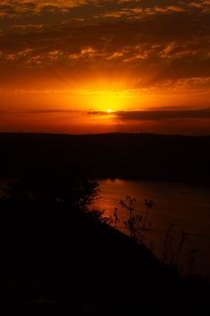 A breathtaking sunset over calm waters with vibrant orange and red hues.