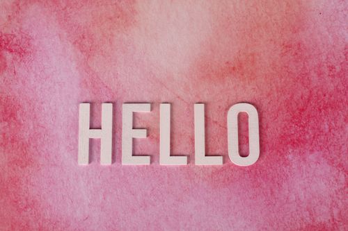 Free Pink textured background with bold white 'HELLO' text for greetings and communication. Stock Photo