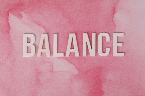 Free The word 'BALANCE' displayed in bold letters on a pink abstract background. Stock Photo