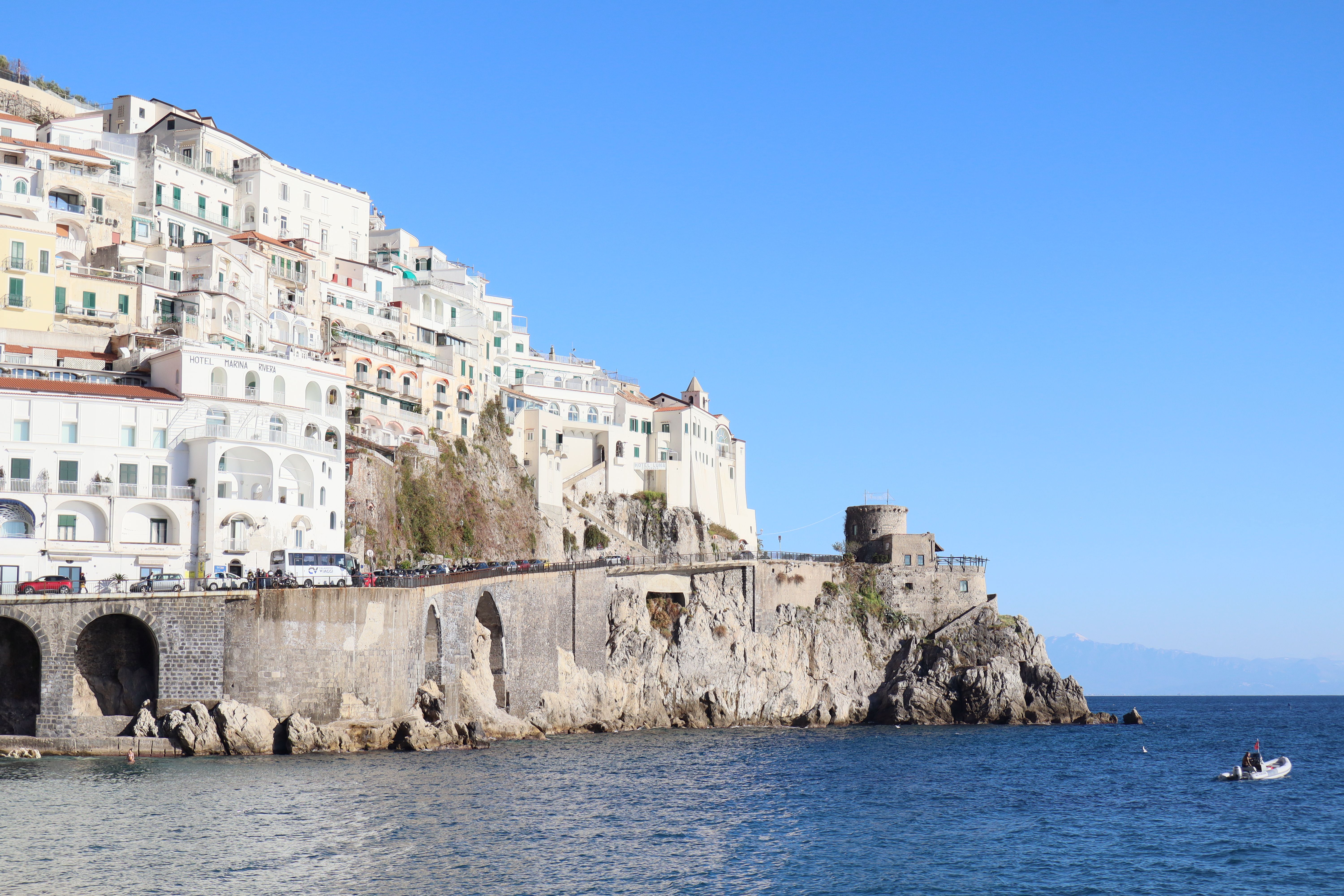 Scenic view of Amalfi coastline with clear blue skies and crystal clear water.