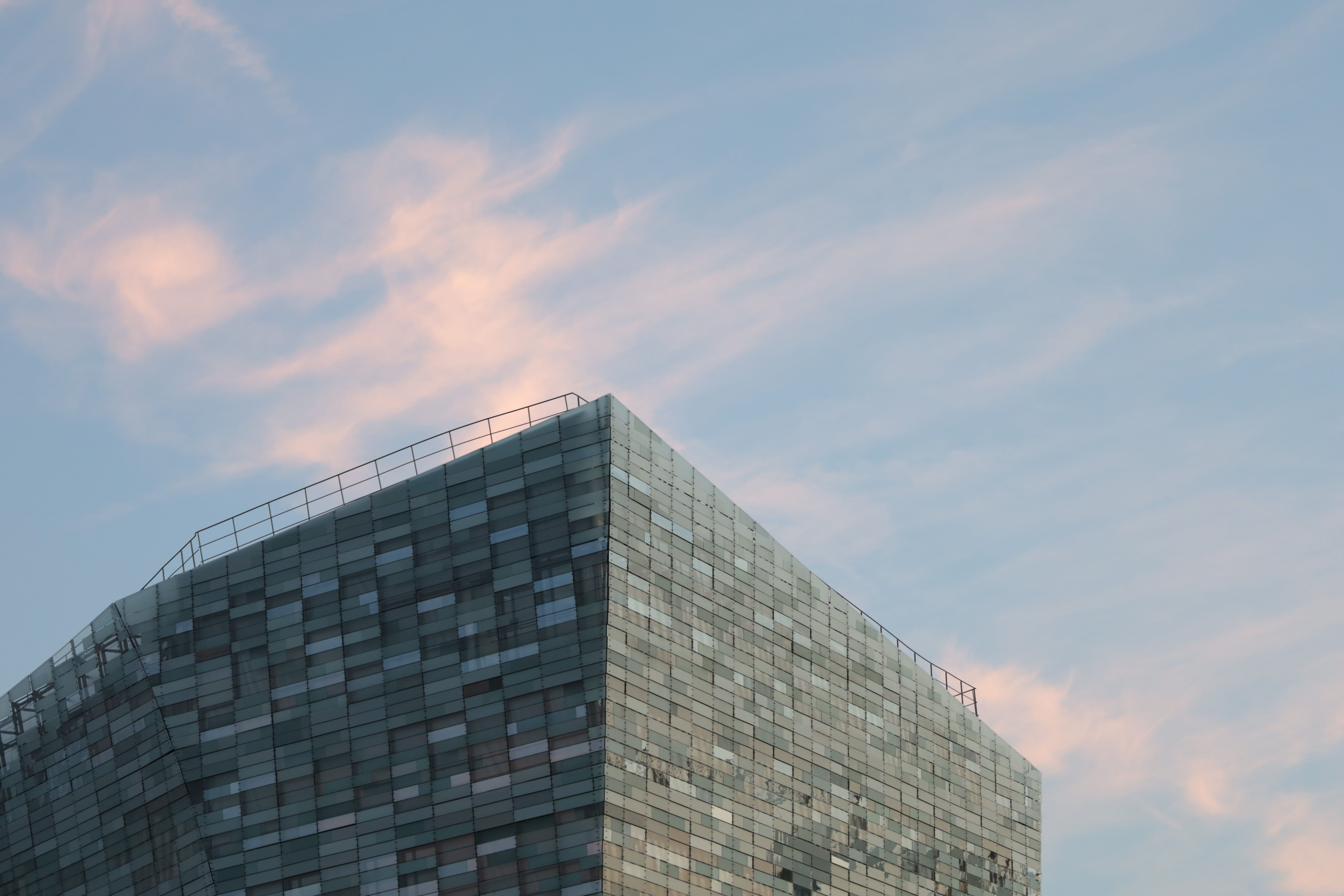 Minimalist architectural detail of a modern glass skyscraper at twilight representing structural integrity and global reach.