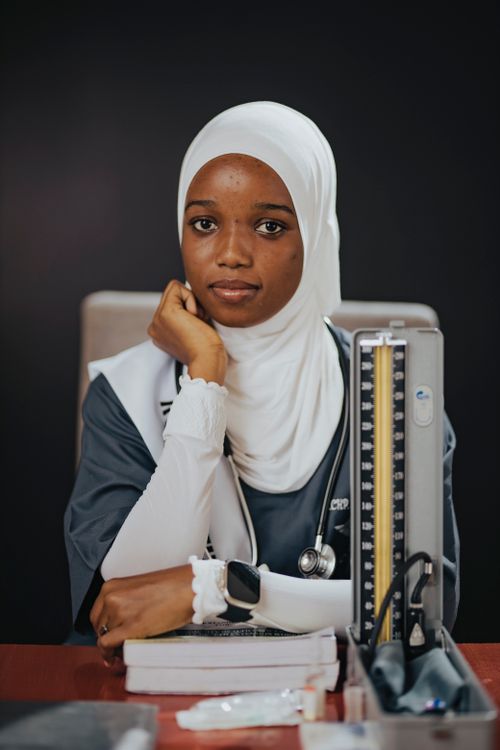 Free Portrait of a female medical student wearing a hijab, sitting with medical tools. Stock Photo