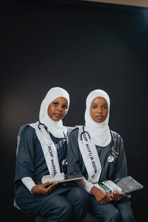 Free Two female medical graduates in hijabs holding diplomas and wearing stethoscopes. Stock Photo