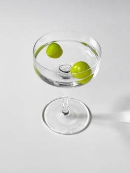 Sophisticated martini with green olives in a crystal clear cocktail glass.