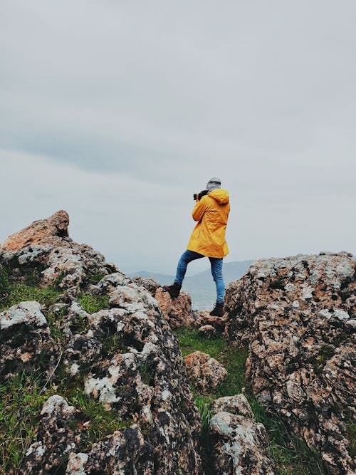 Mann, Der Auf Felsen Beim Fotografieren Steht