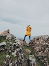 Man Standing on Rock While Taking Photo