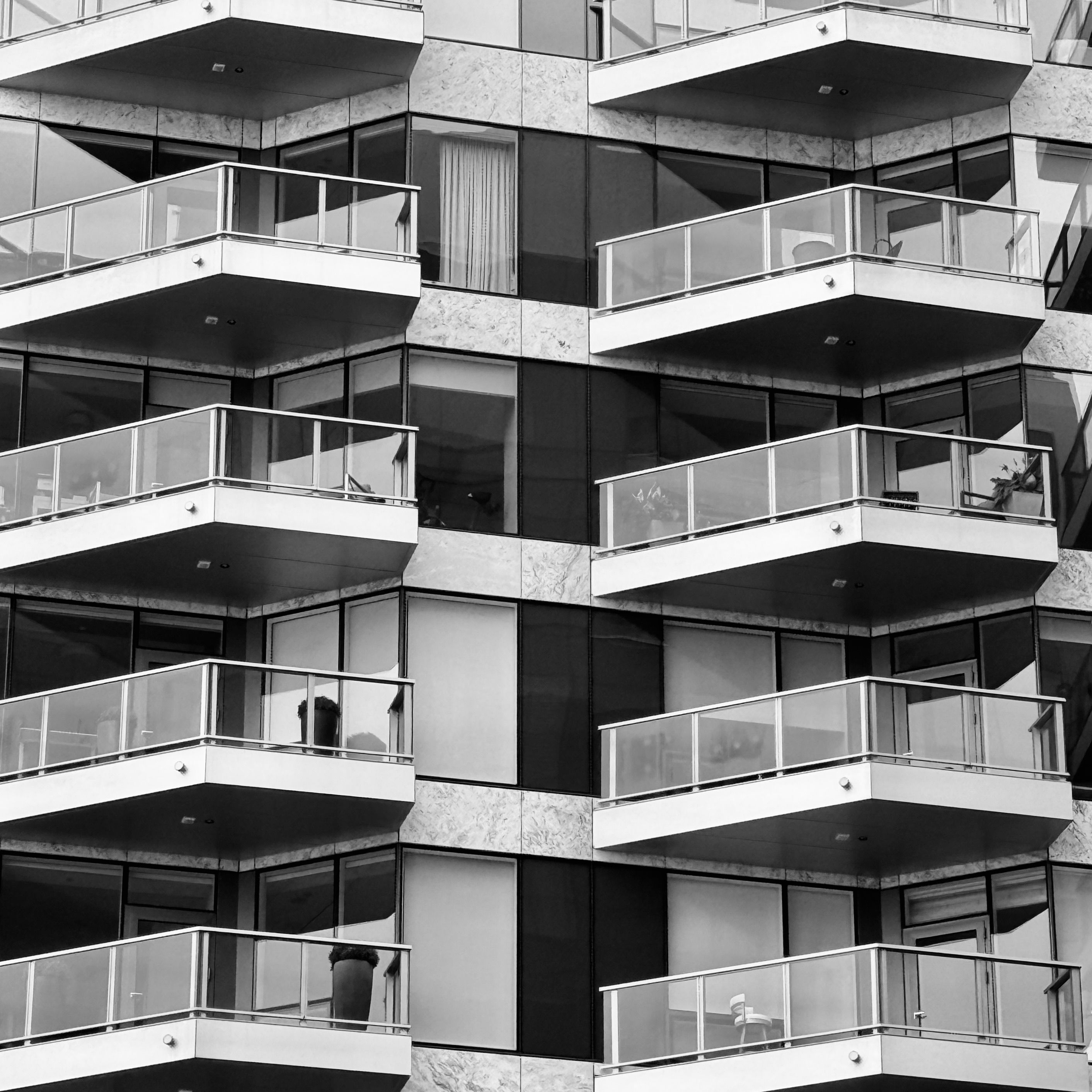 Black and white view of a modern apartment building with balconies.