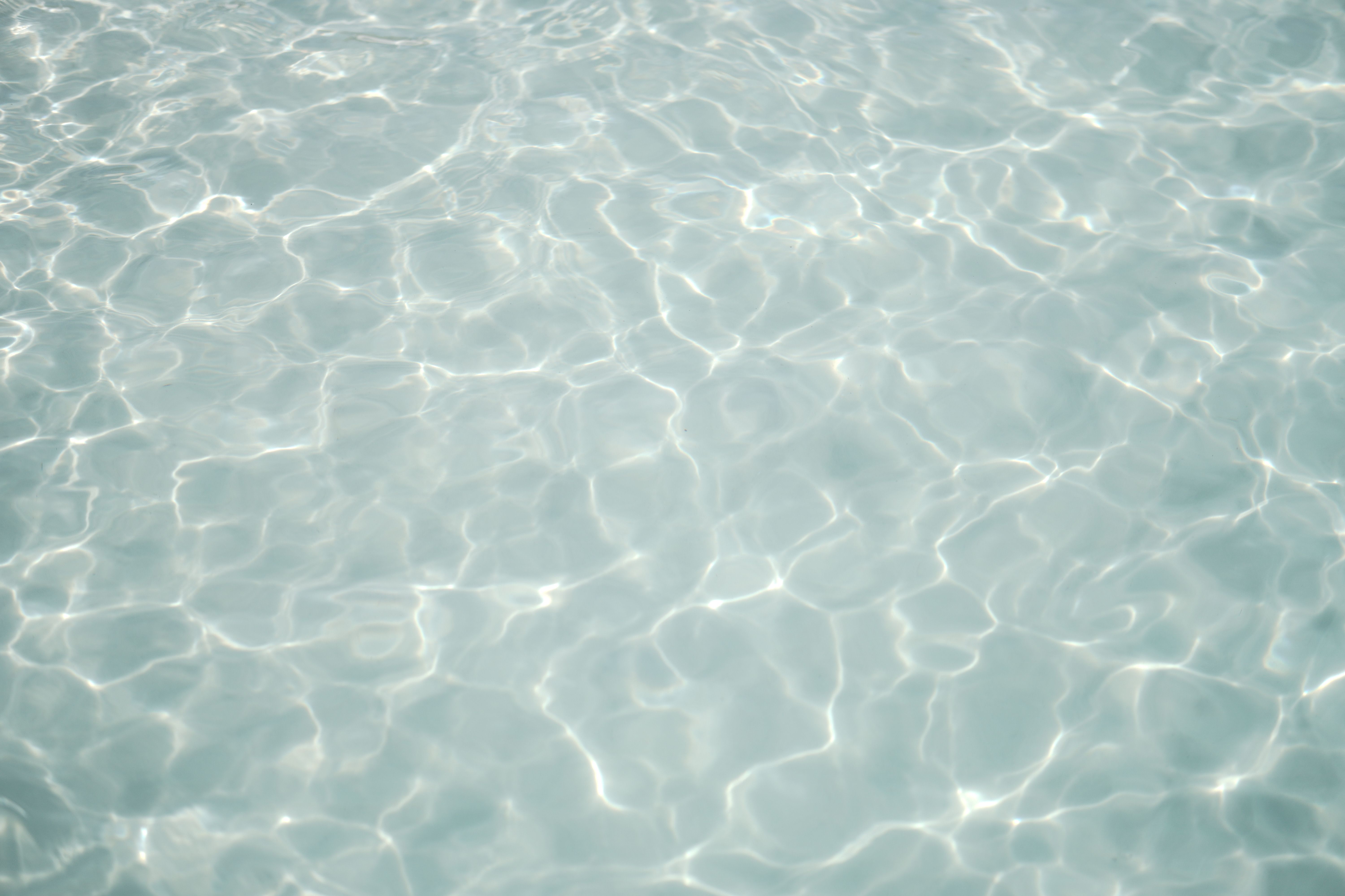 Peaceful water surface with ripples and sunlight reflection creating a serene ambiance.