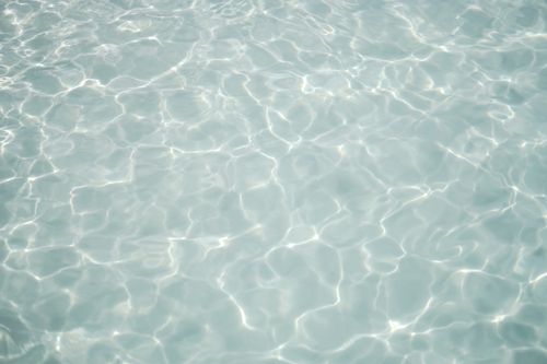 Free Peaceful water surface with ripples and sunlight reflection creating a serene ambiance. Stock Photo