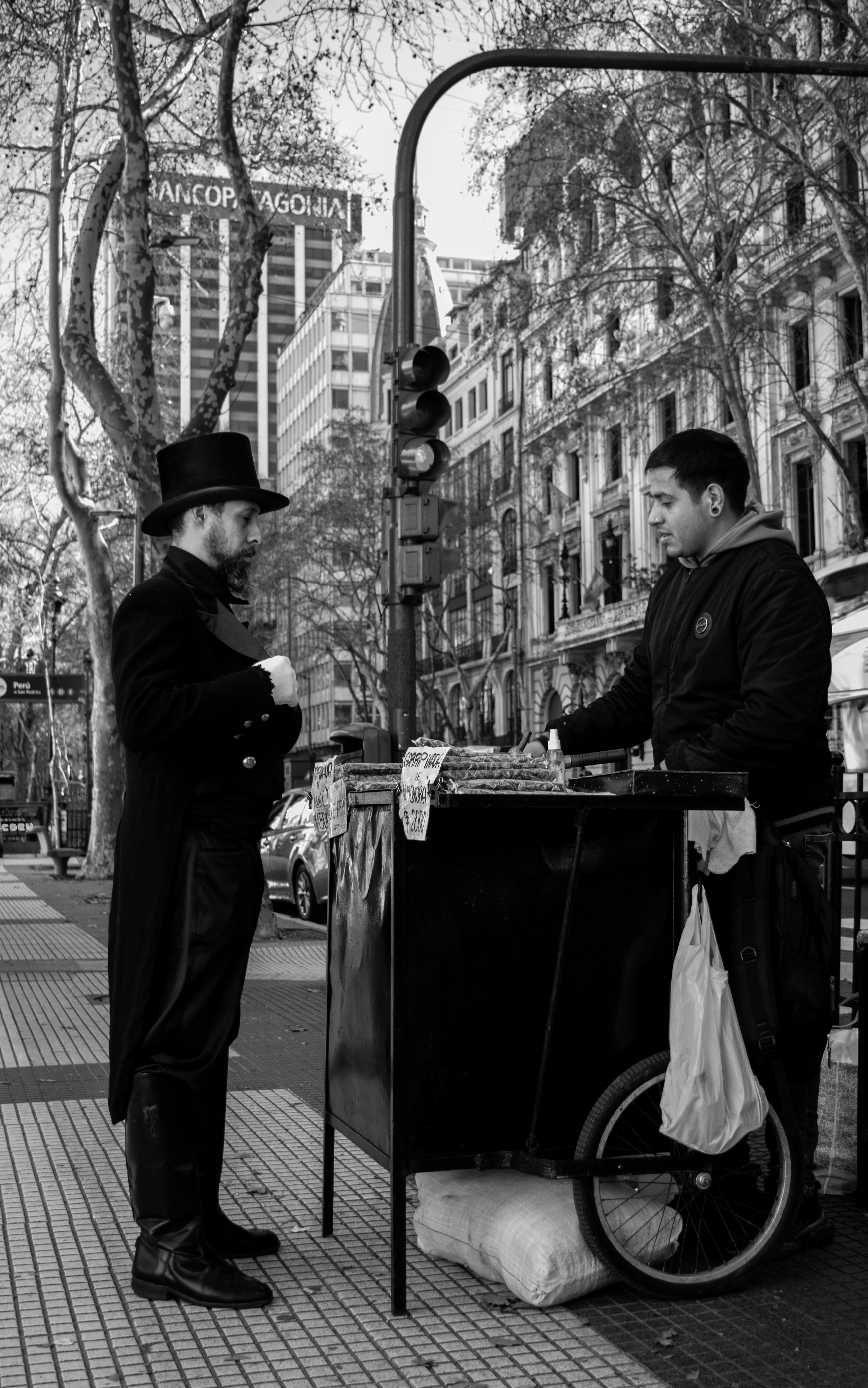 A candid shot capturing two men in conversation by a street food cart in Buenos Aires.