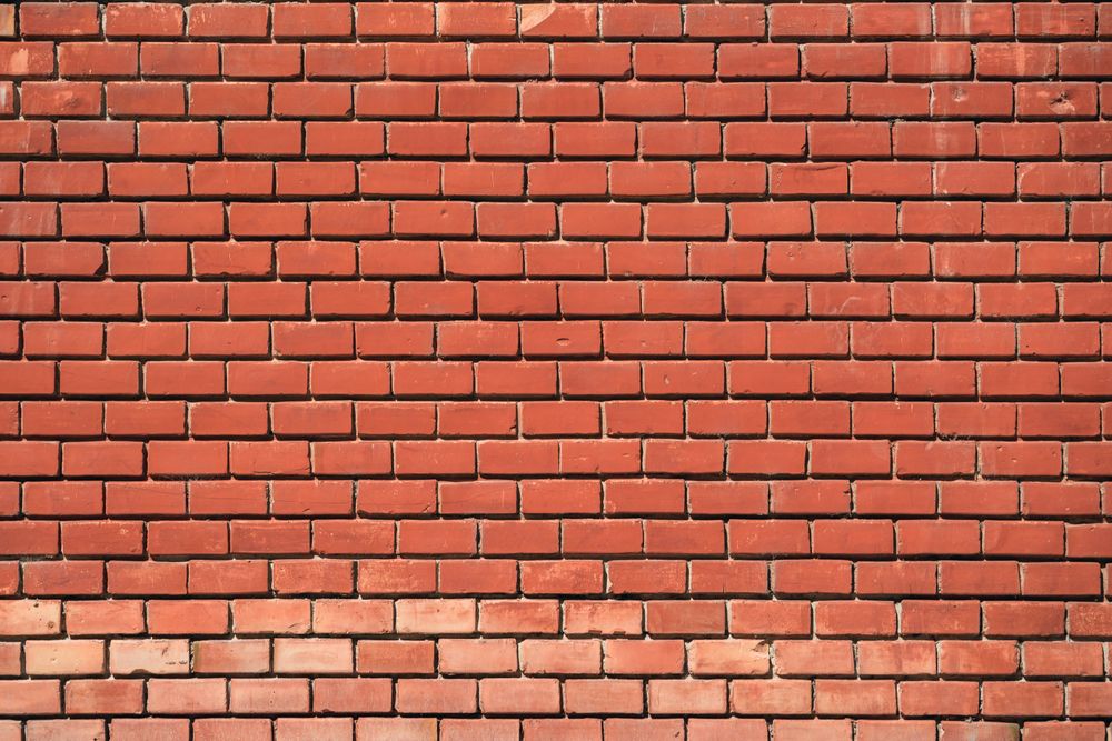 A sunlit exposed brick wall in a warm interior