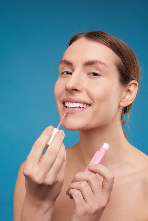 Woman Putting on Pink Lipstick