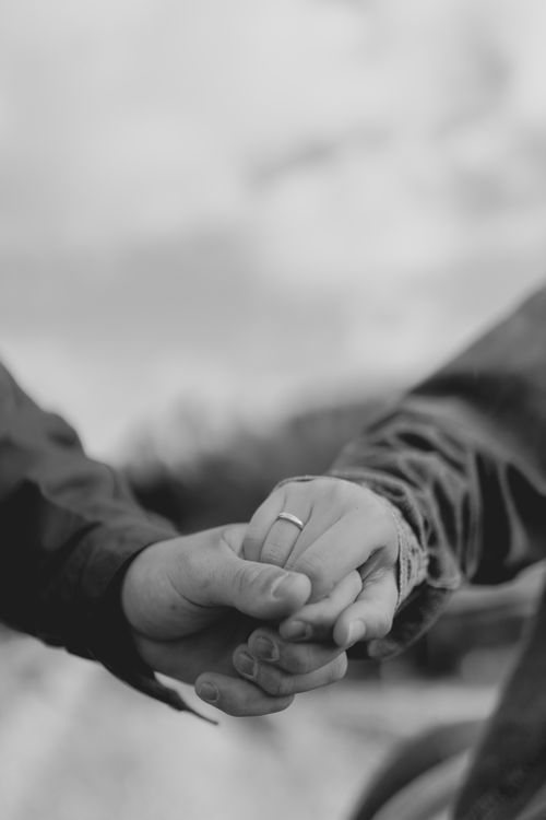 Free Intimate black and white image of two hands holding, symbolizing love and connection. Stock Photo
