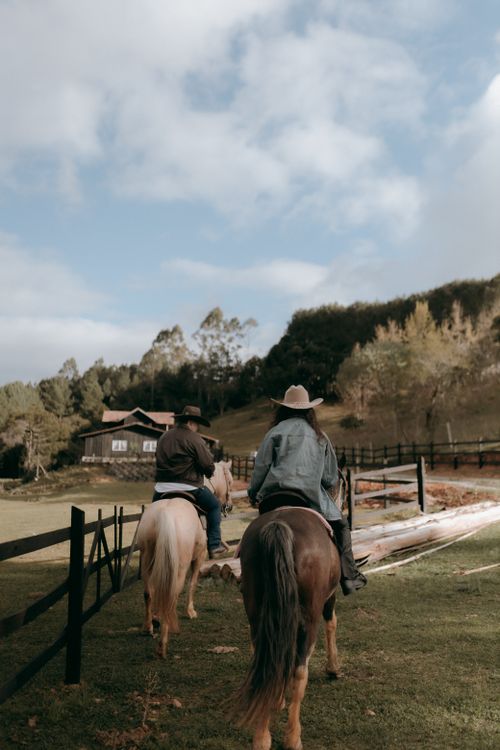 Free Two cowboys riding horses on a serene rural ranch, showcasing western lifestyle and scenic countryside. Stock Photo