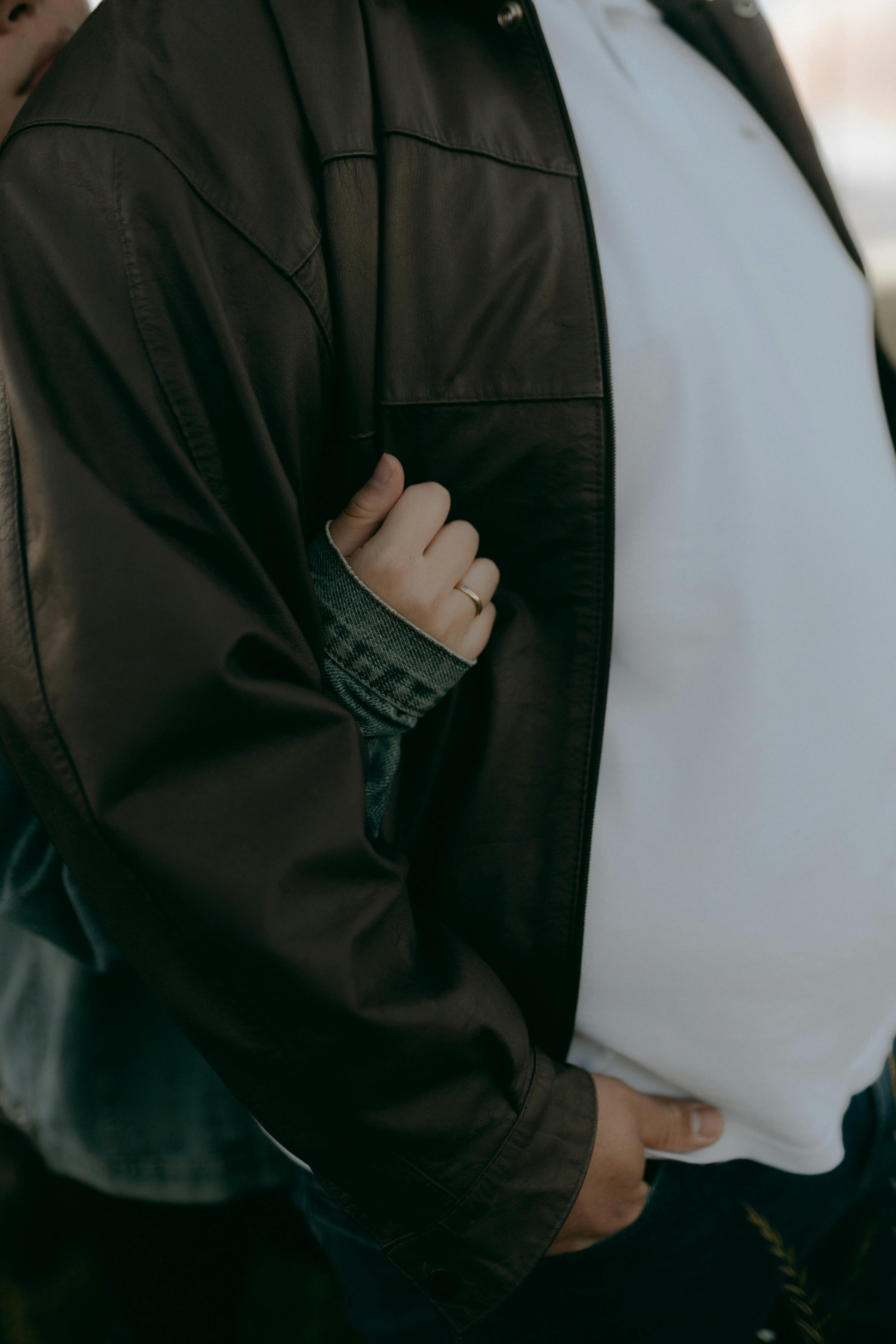 Gratuit Prim-plan intim al unui cuplu ținându-se de mână în jachete lejere, creând o conexiune caldă și personală. Fotografie de stoc