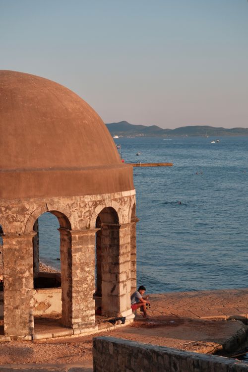 Free Serene sunset at Zadar beach featuring an ancient dome and calm sea view. Stock Photo