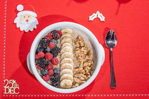 Festive breakfast bowl with blackberries, raspberries, banana, and walnuts on a Christmas tablecloth.