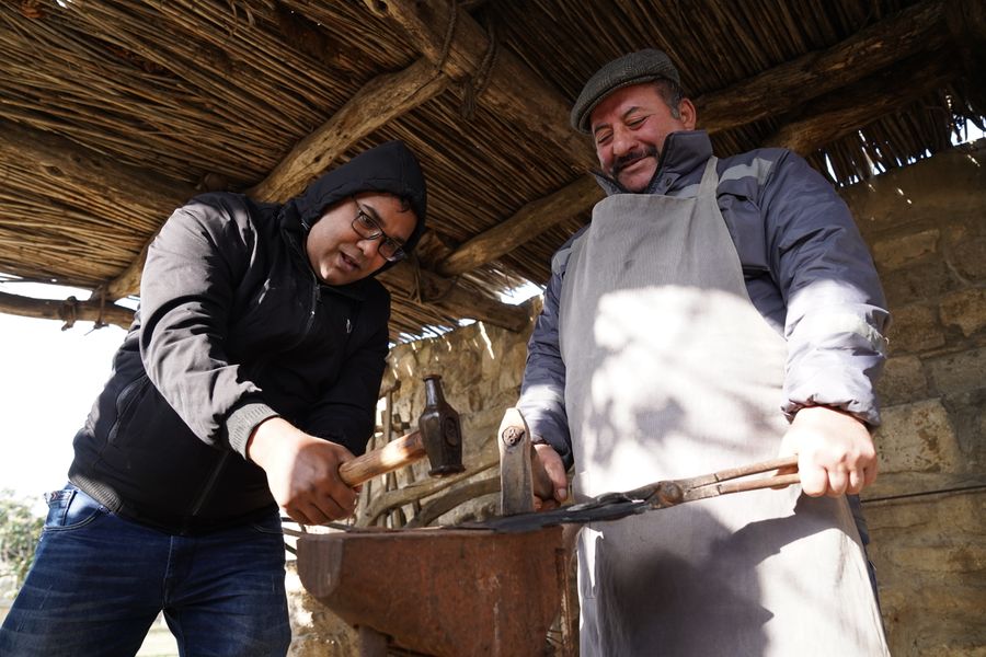Dos personas trabajando juntas en la fragua