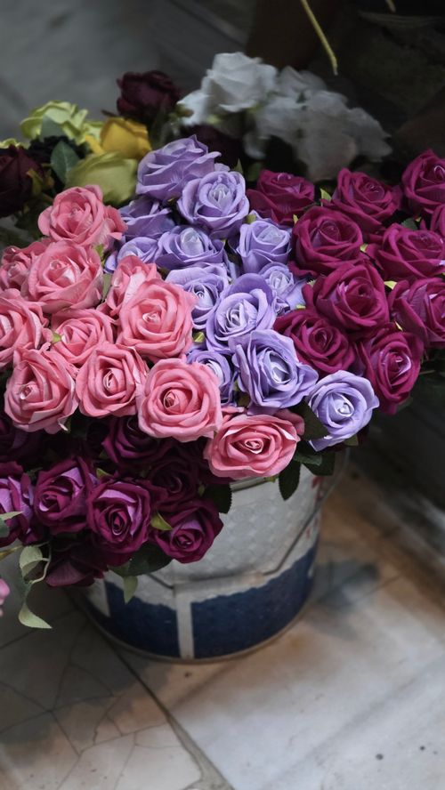 Free A vibrant bouquet of pink and purple roses arranged in a decorative vase, creating a stunning floral display. Stock Photo