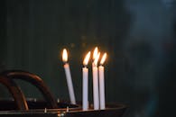 Lit Candles in Holder Against Dark Background