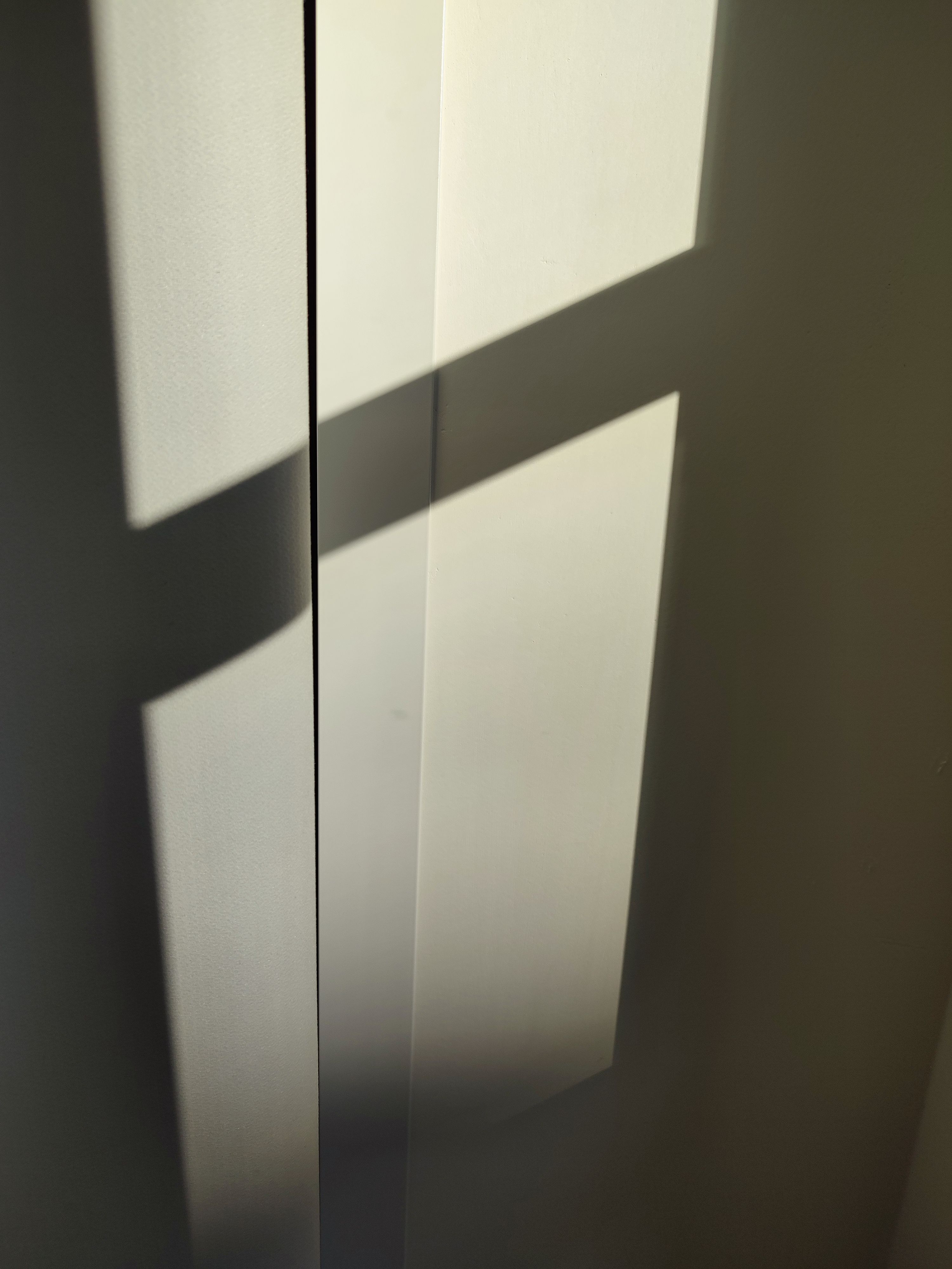 grátis Uma composição minimalista que mostra a luz do sol projetando sombras geométricas em uma parede, transmitindo simplicidade e aconchego. Foto profissional