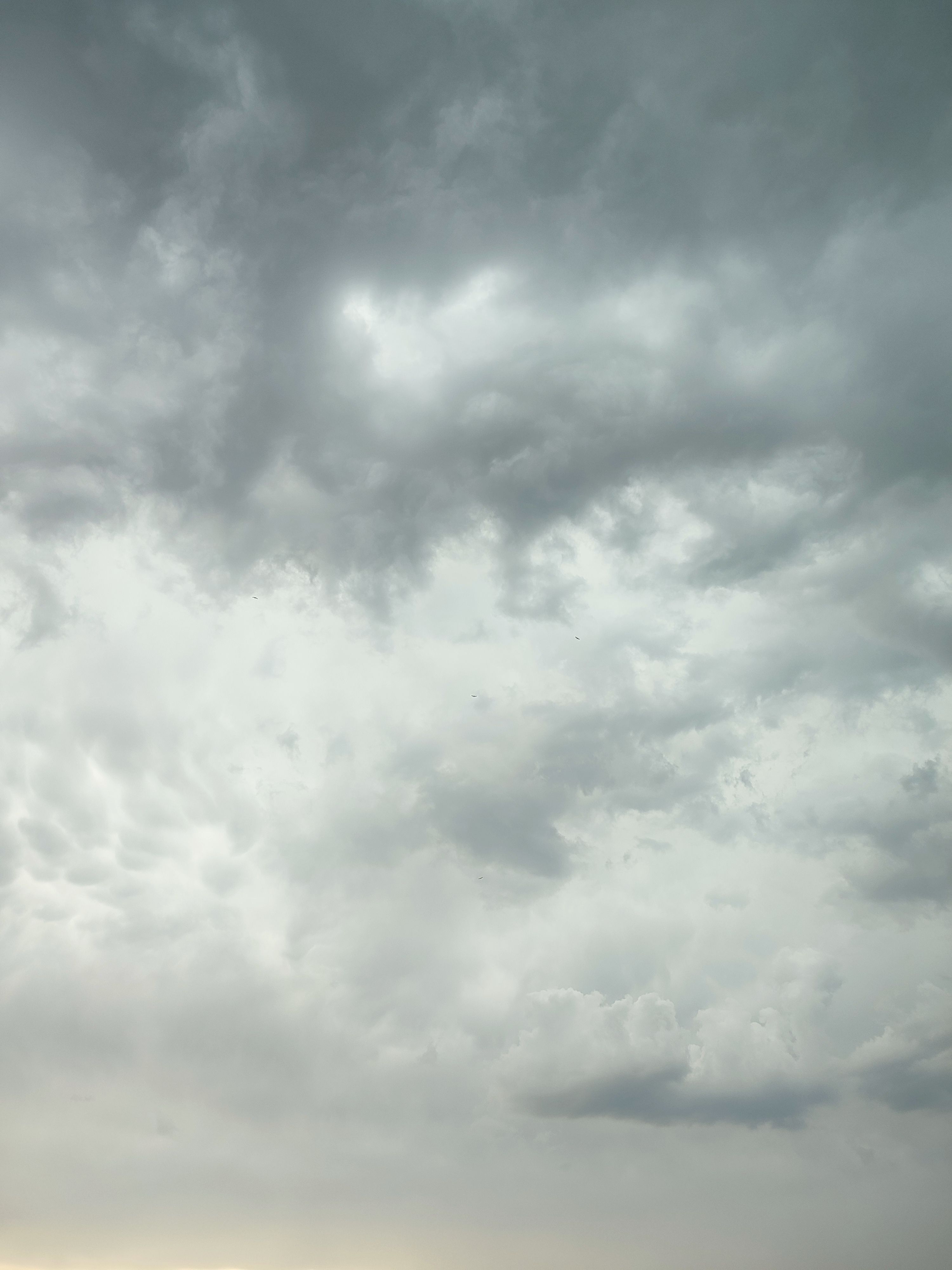 grátis Um céu dramático cheio de nuvens espessas, sugerindo uma tempestade iminente, capturado em uma fotografia atmosférica deslumbrante. Foto profissional