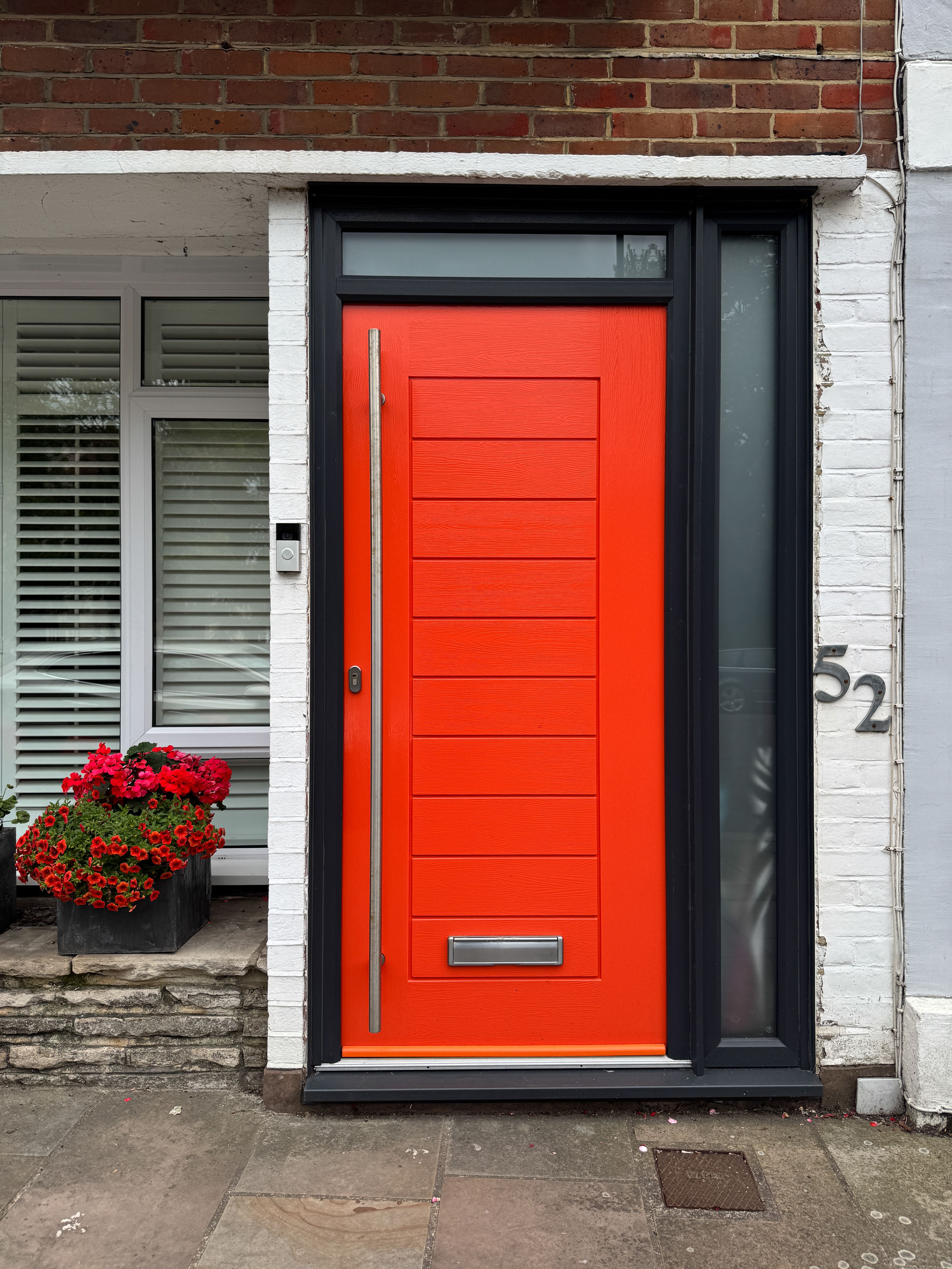 Striking orange front door with black accents in Portsmouth, England.