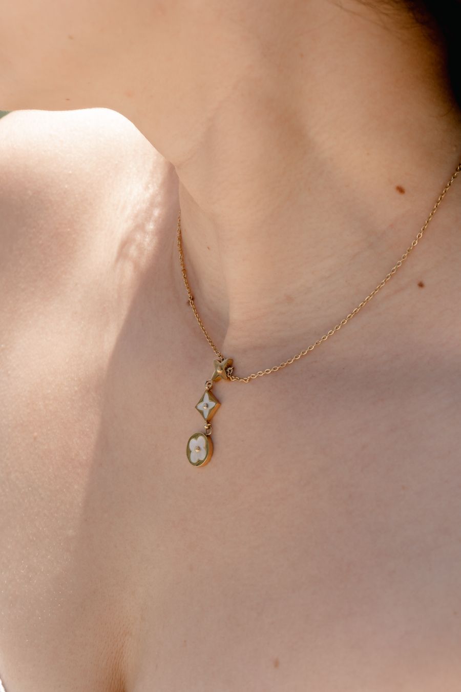 Gold necklace on a woman’s neck under sunlight