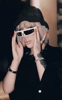 Trendy young woman wearing sunglasses and a hat, posing confidently.