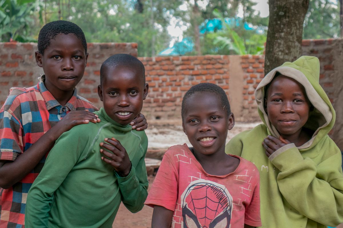 Four cheerful children posing together outdoors with bright smiles