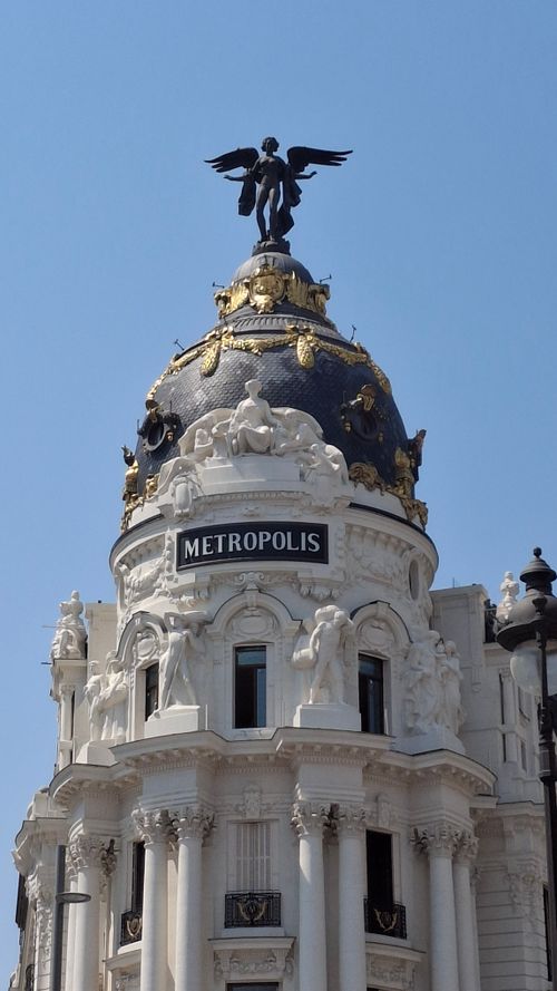 Free Iconic Metropolis Building in Madrid, featuring detailed architecture and a prominent angel statue. Stock Photo
